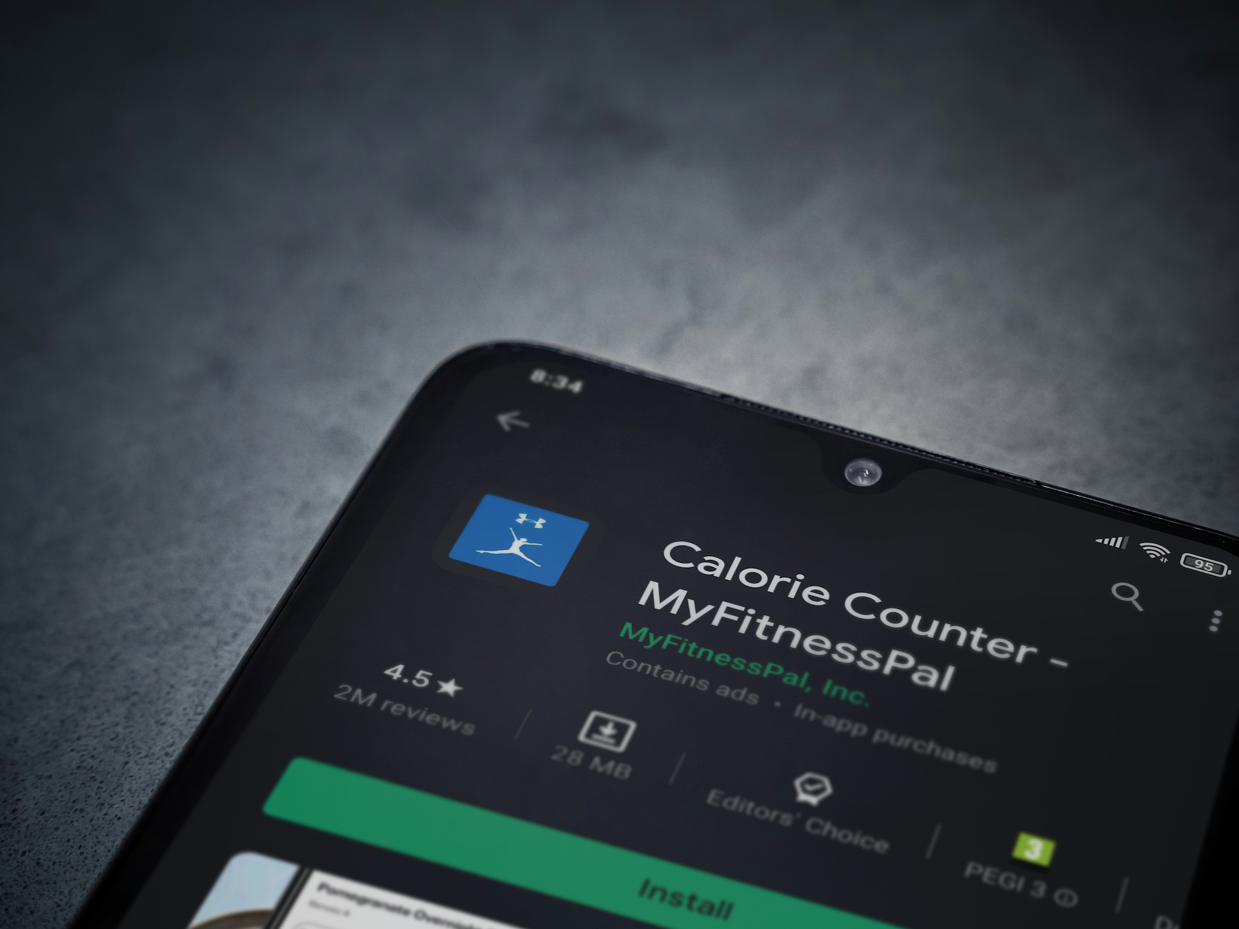Lod, Israel - July 8, 2020: MyFitnessPal app play store page on the display of a black mobile smartphone on dark marble stone background. Top view flat lay with copy space.
