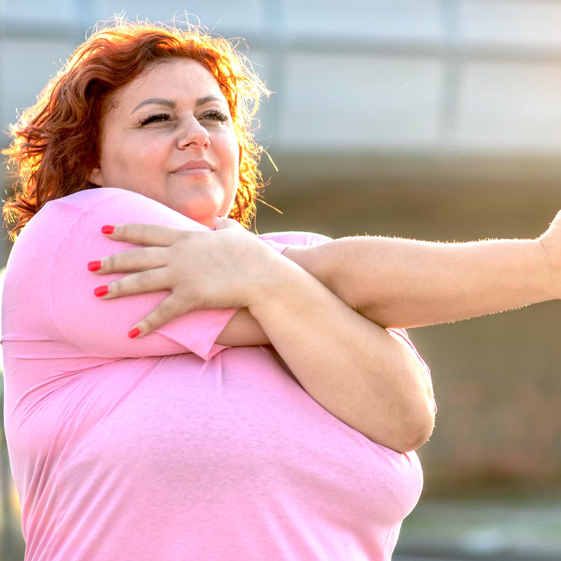Young obese woman doing weight loss training, gymnastics exercises on a beautiful sunny day