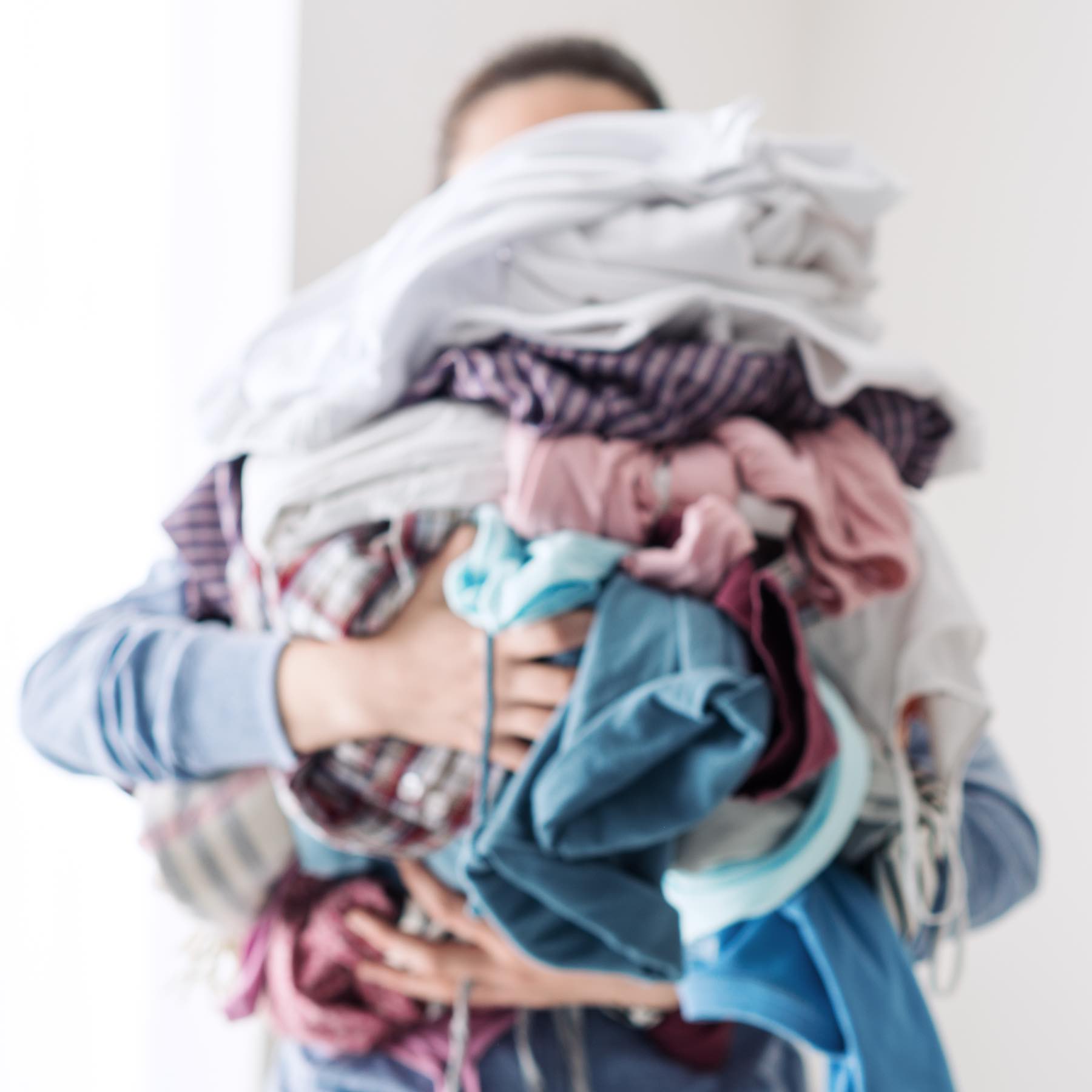 Housewife bringing a huge pile of laundry on the ironing board, boring household chores concept