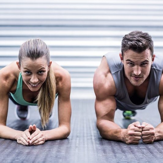 a man and woman doing plank exercises together